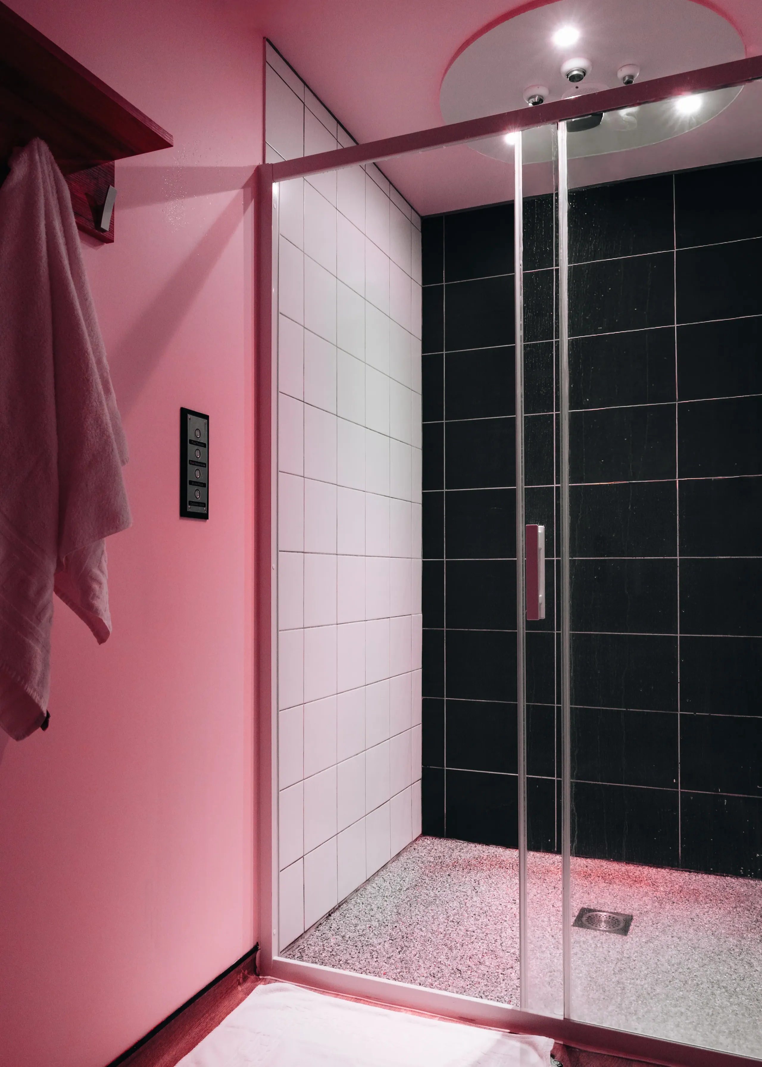 Douche moderne aux murs roses et carreaux noirs