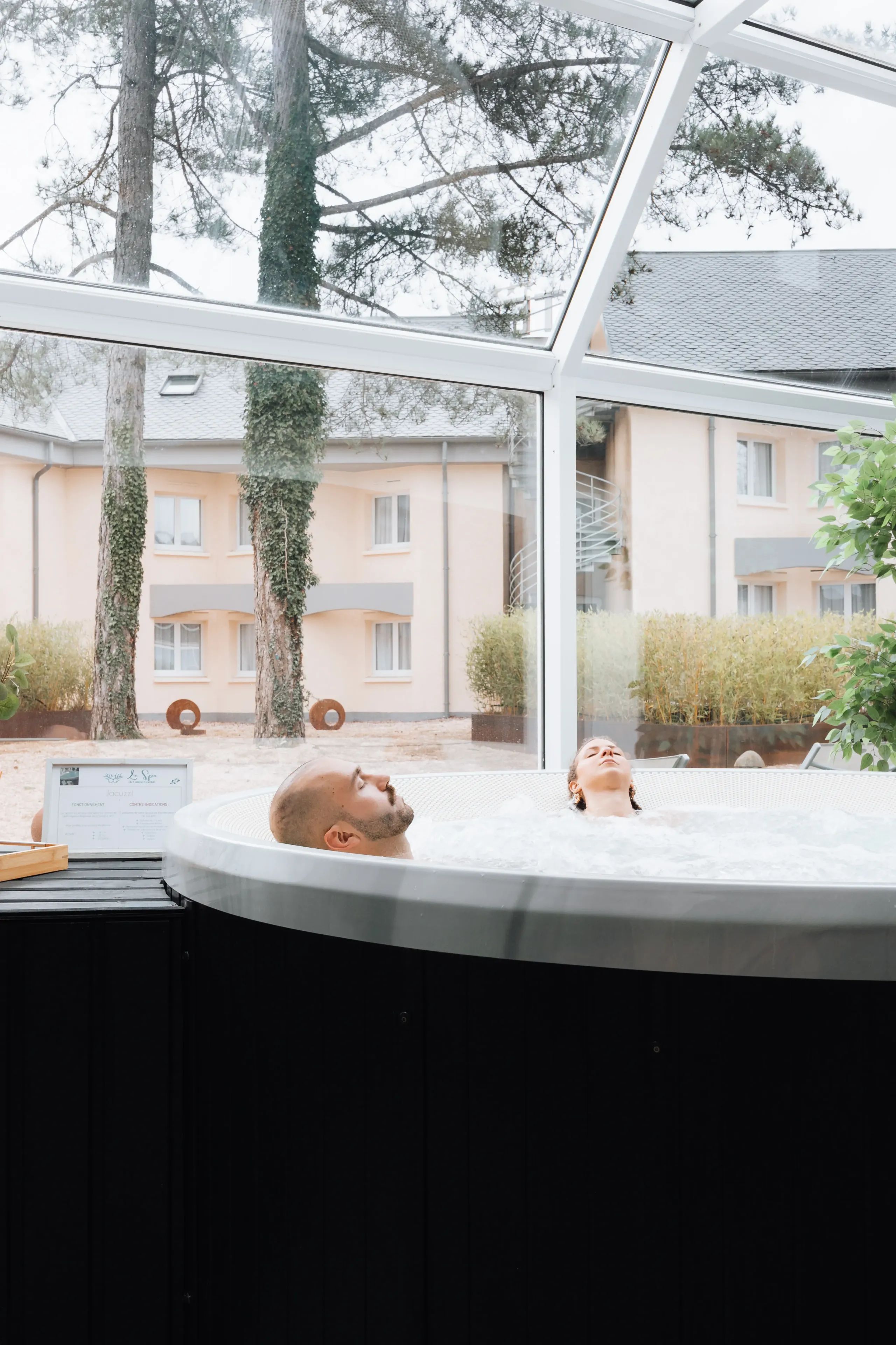 Deux personnes se détendent dans un jacuzzi intérieur.