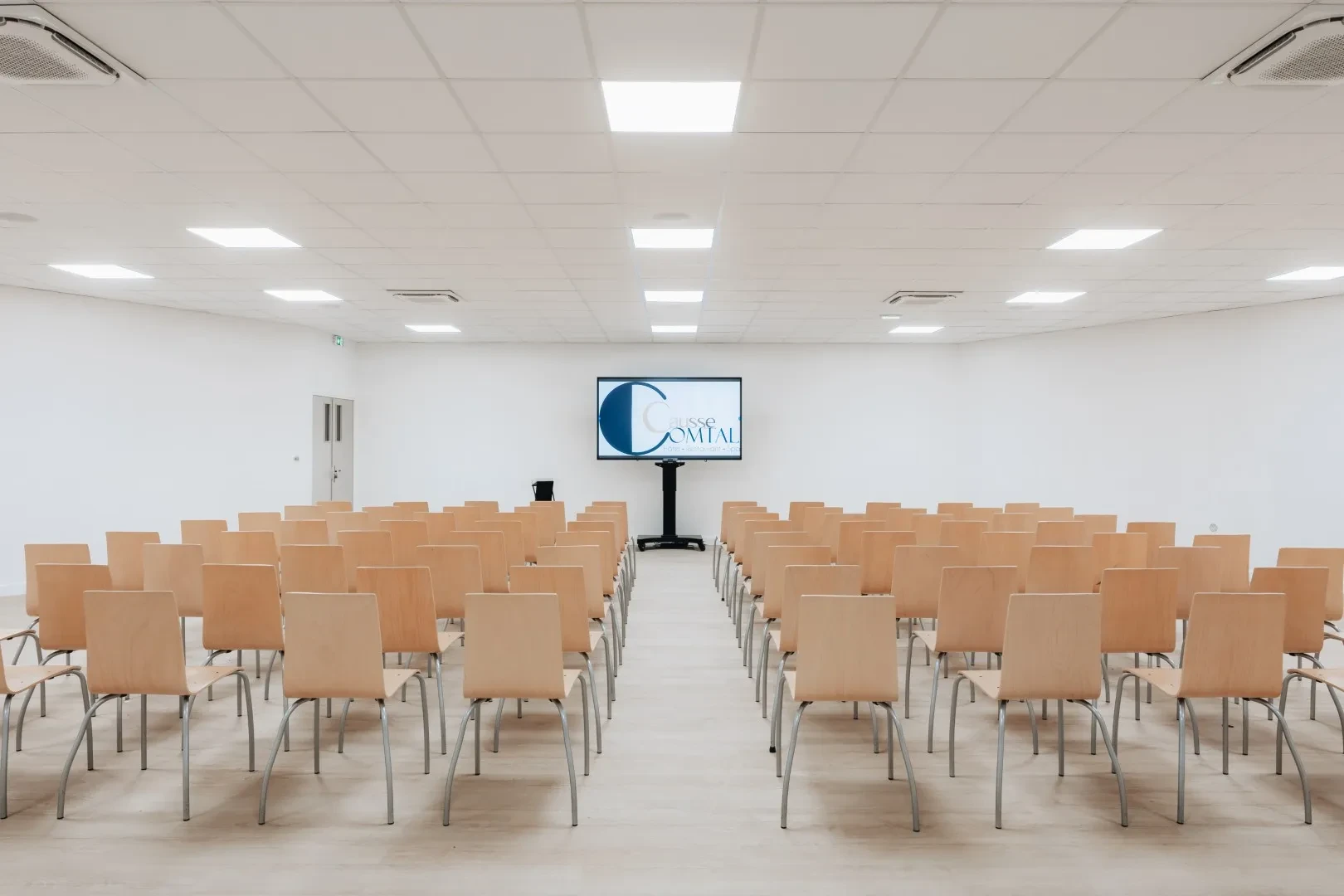 Salle de conférence avec chaises et écran de présentation