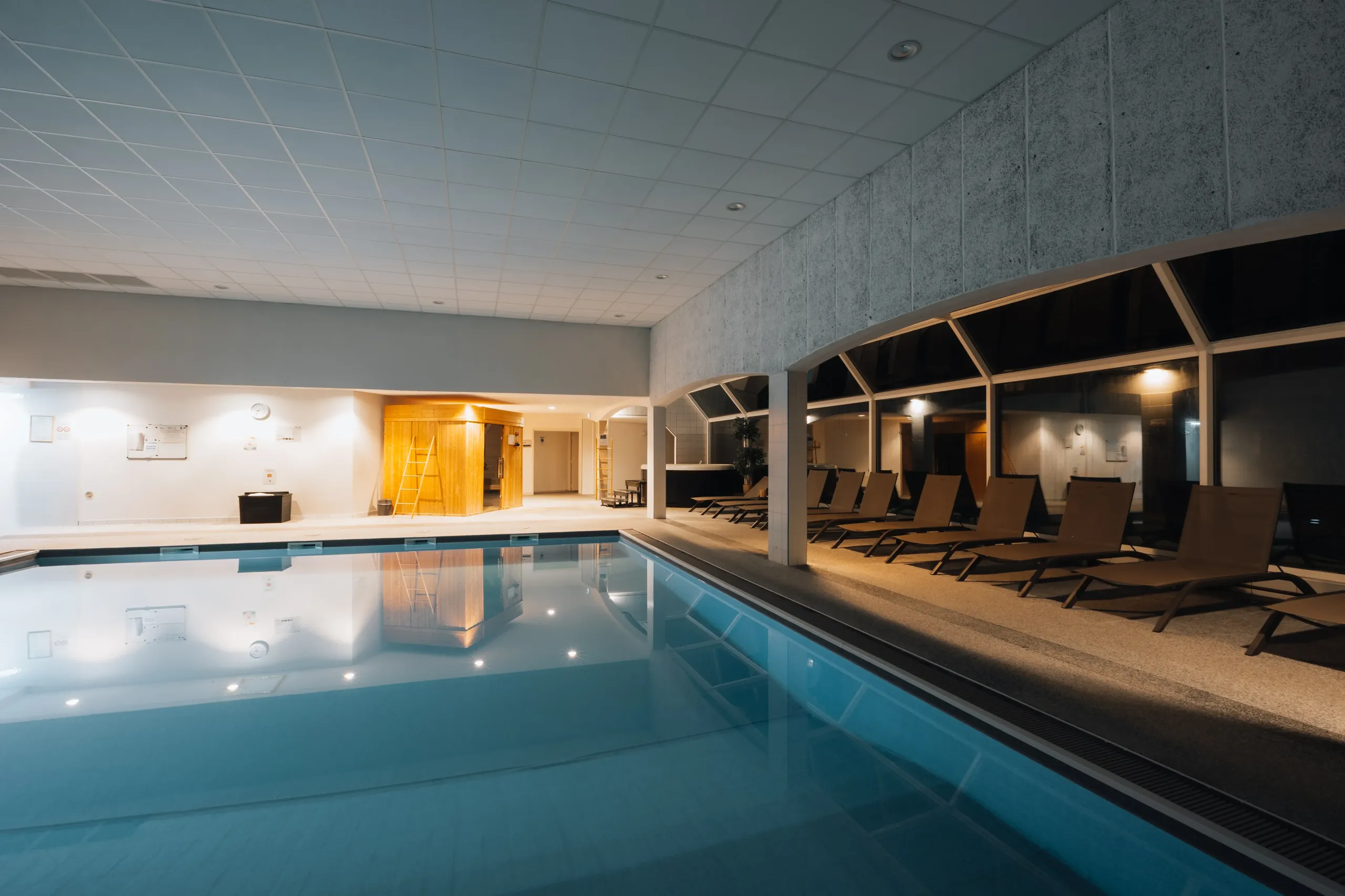 Piscine intérieure avec chaises longues modernes