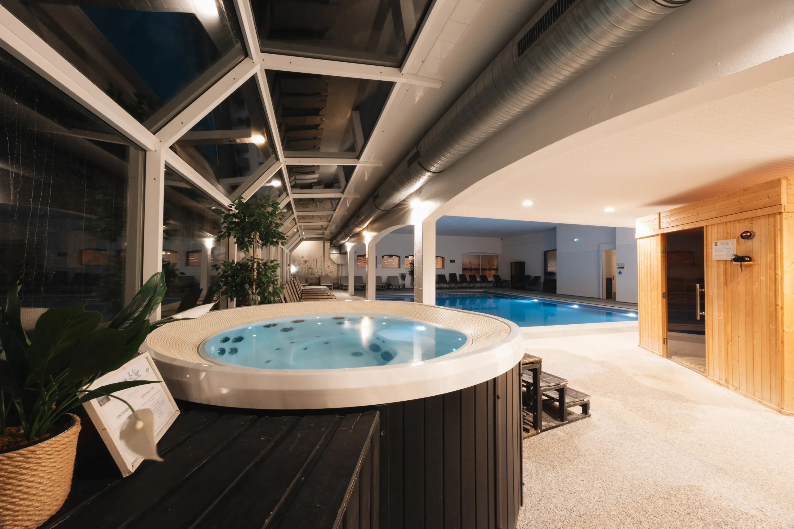 Spa intérieur avec jacuzzi, piscine et sauna.