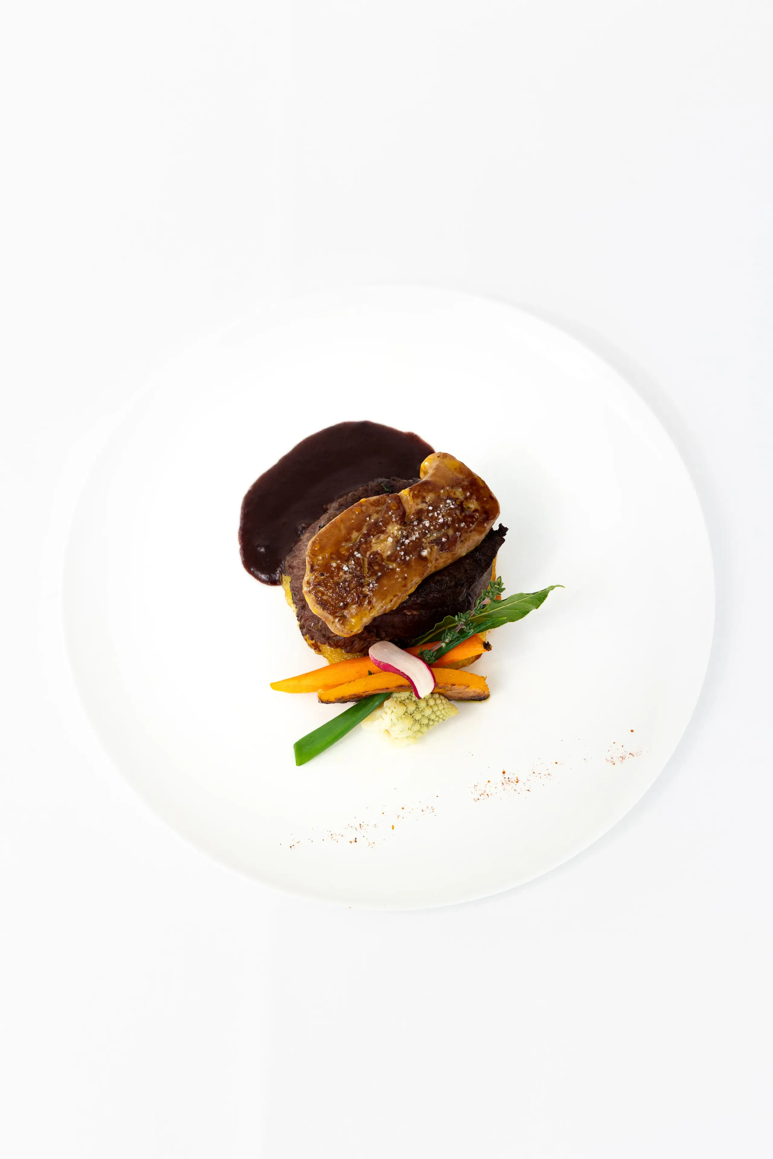 Plat gastronomique viande, foie gras et légumes