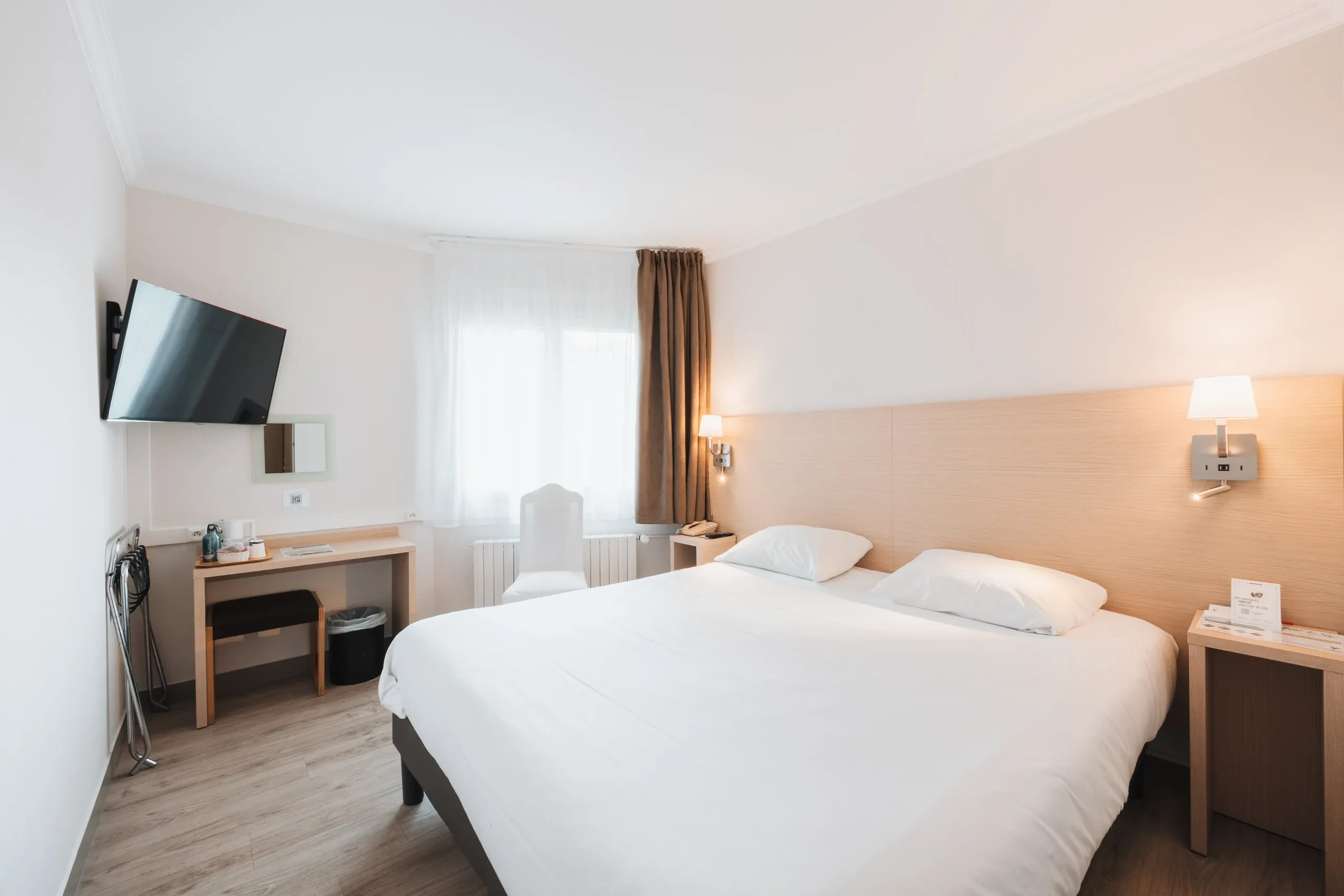 Chambre d’hôtel moderne avec grand lit et bureau