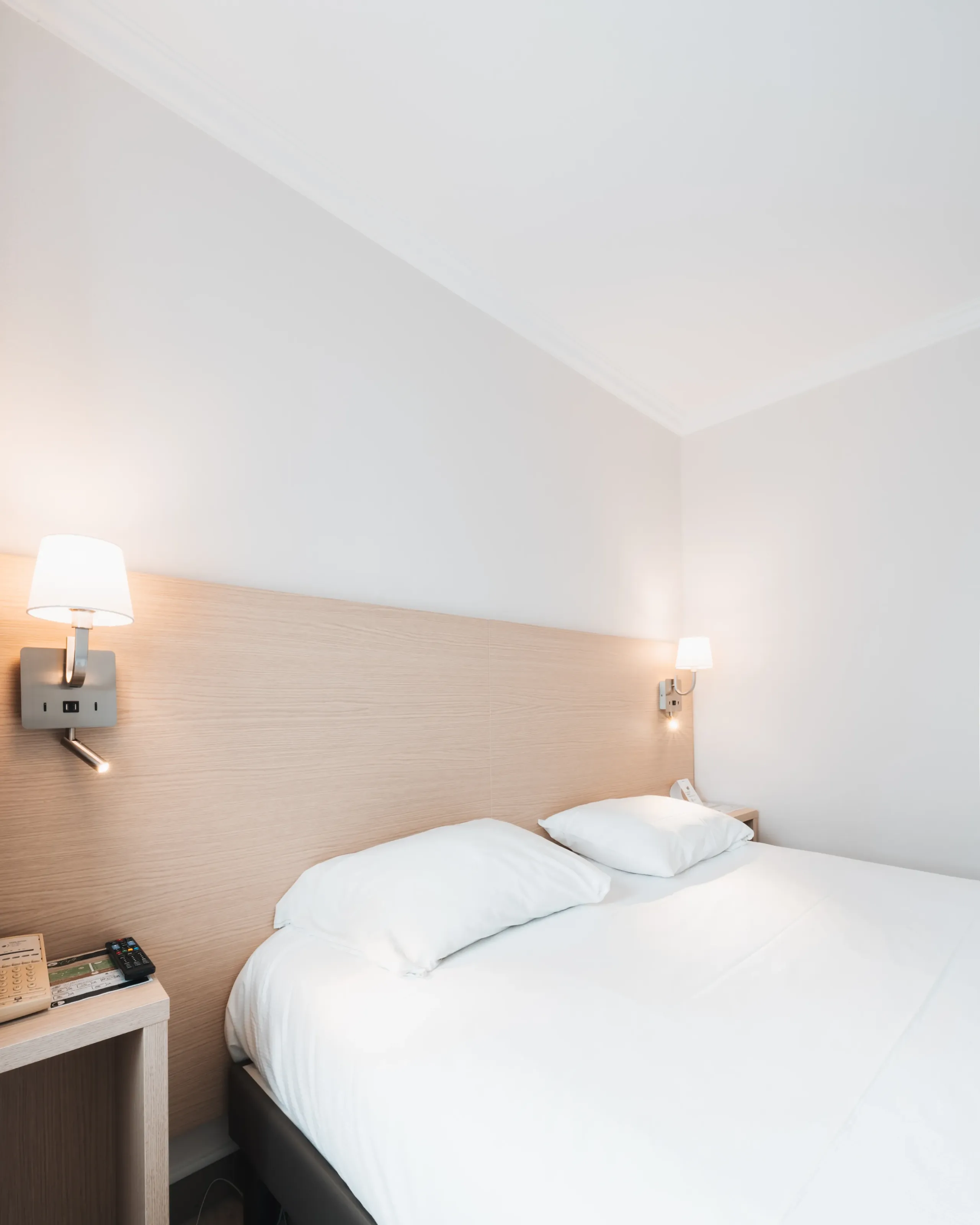 Chambre d’hôtel moderne avec grand lit blanc