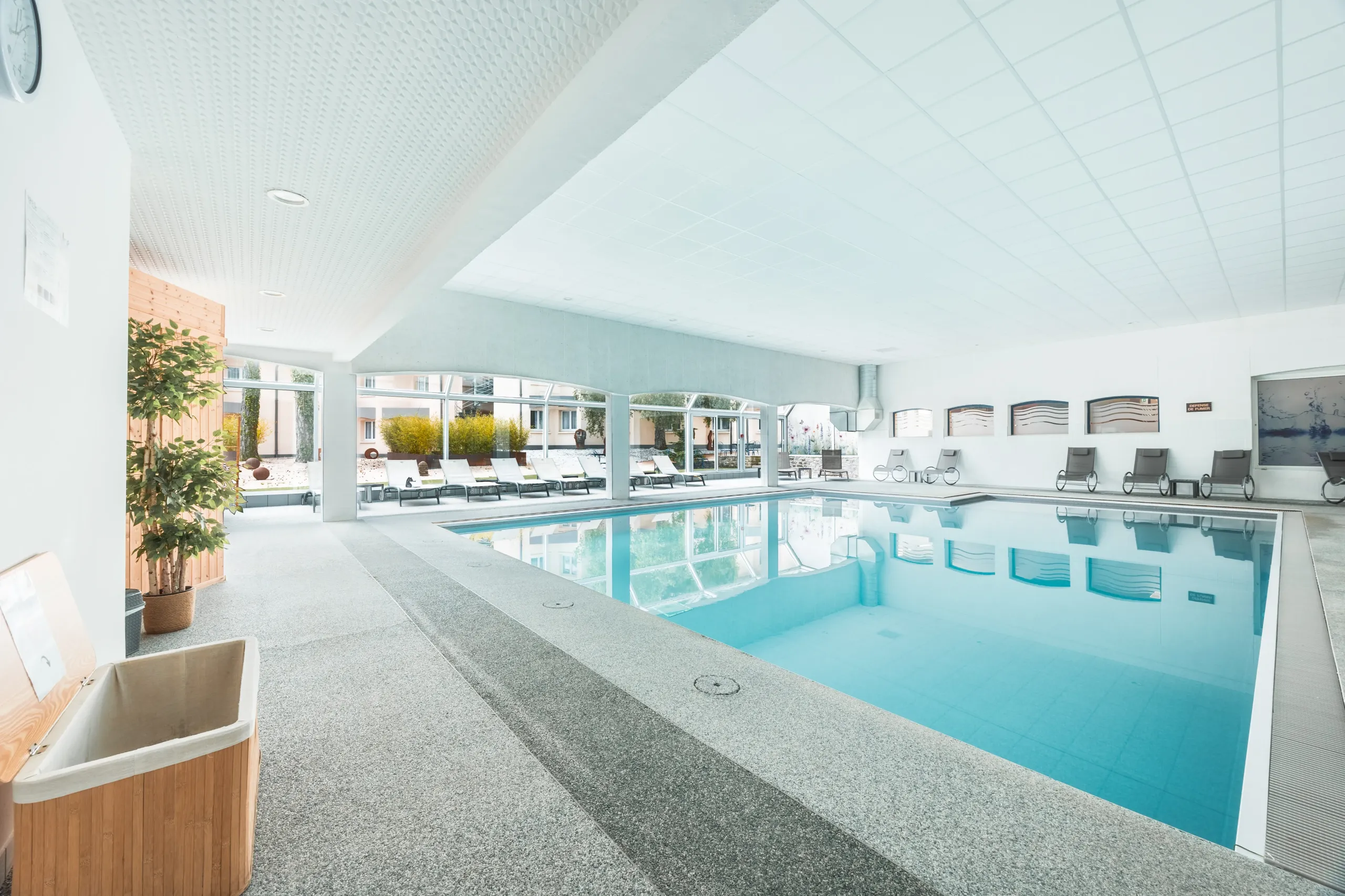 Piscine intérieure moderne avec chaises longues