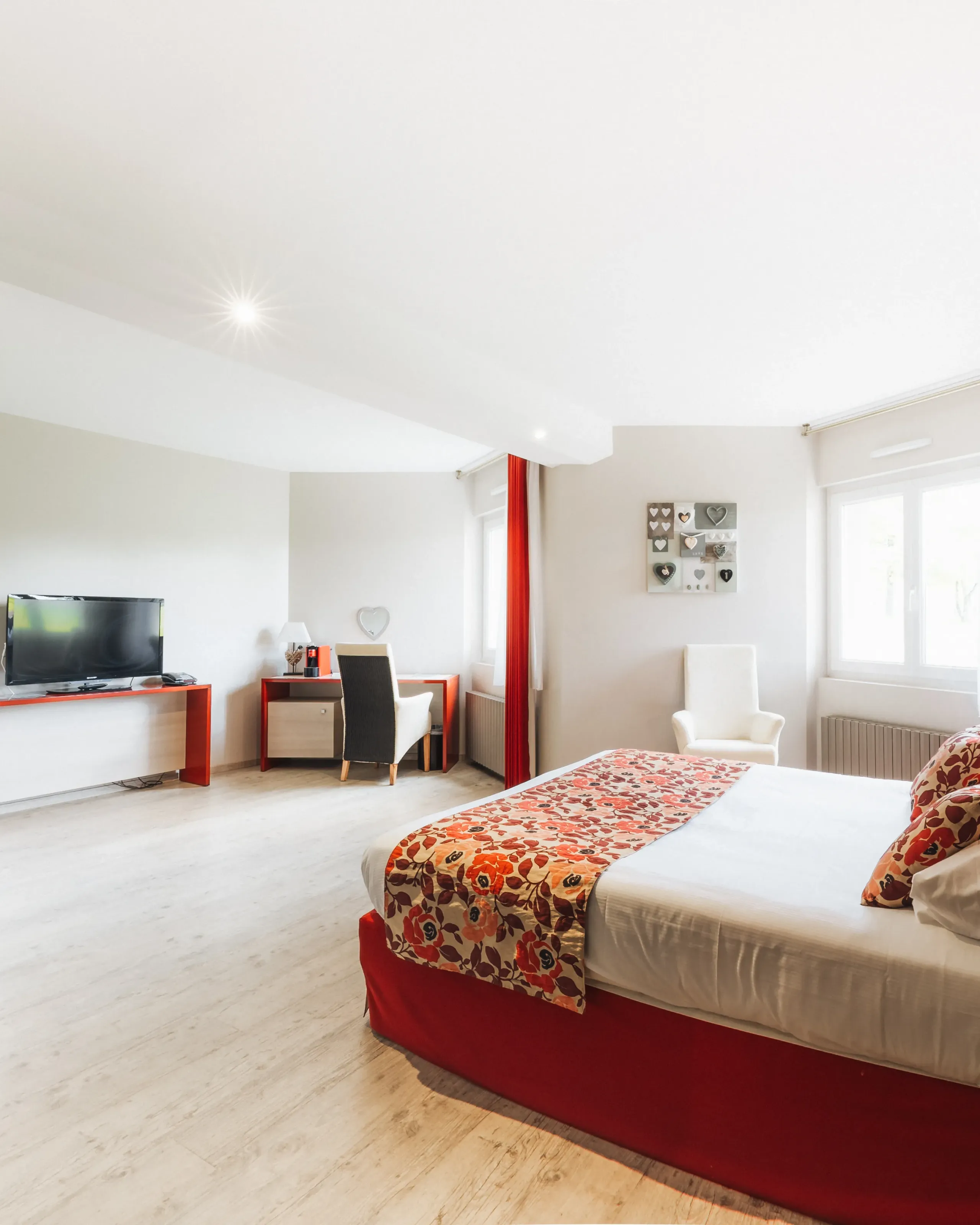 Chambre lumineuse avec lit double et décoration rouge