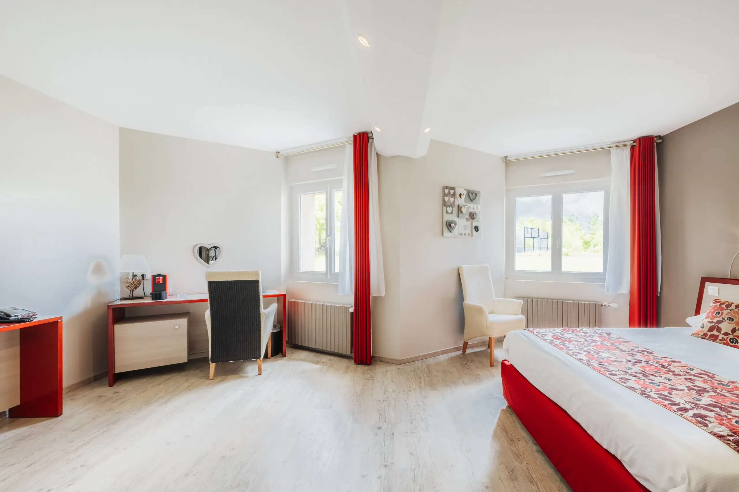 Chambre d'hôtel lumineuse avec lit et bureau