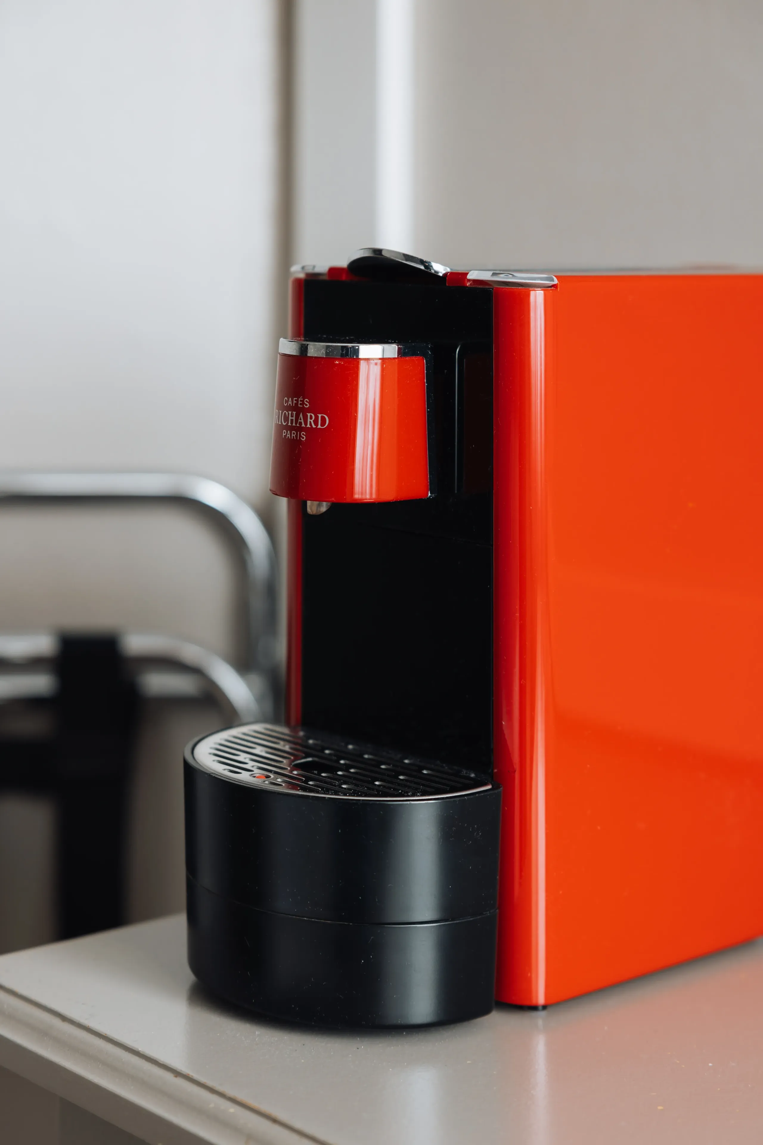 Machine à café rouge sur un comptoir.