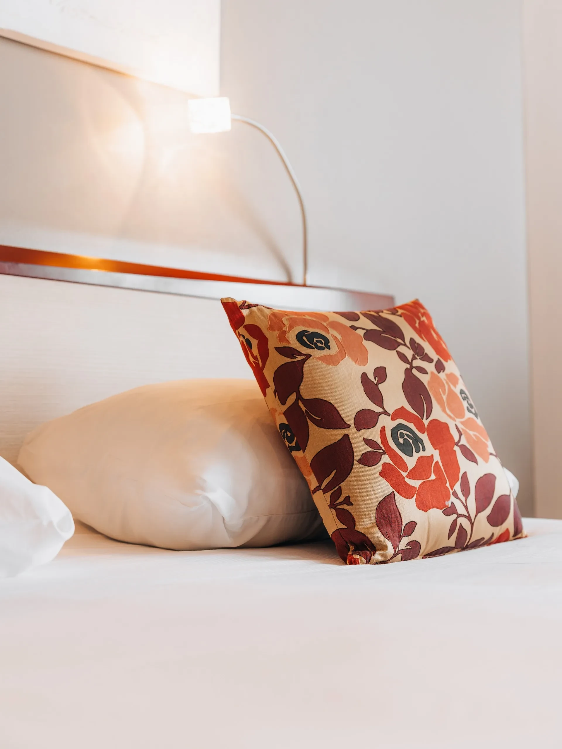 Coussin floral sur lit blanc