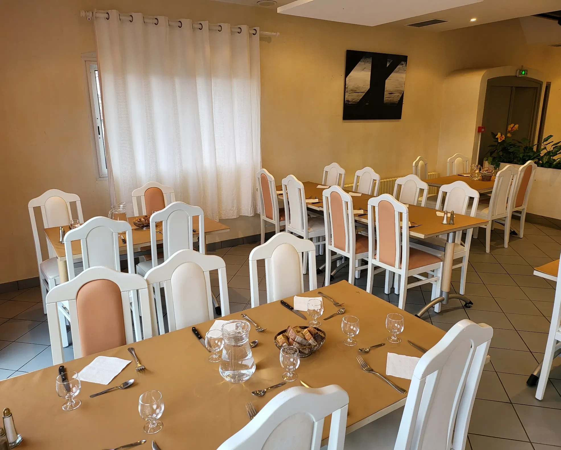 Salle de restaurant avec tables dressées élégamment.