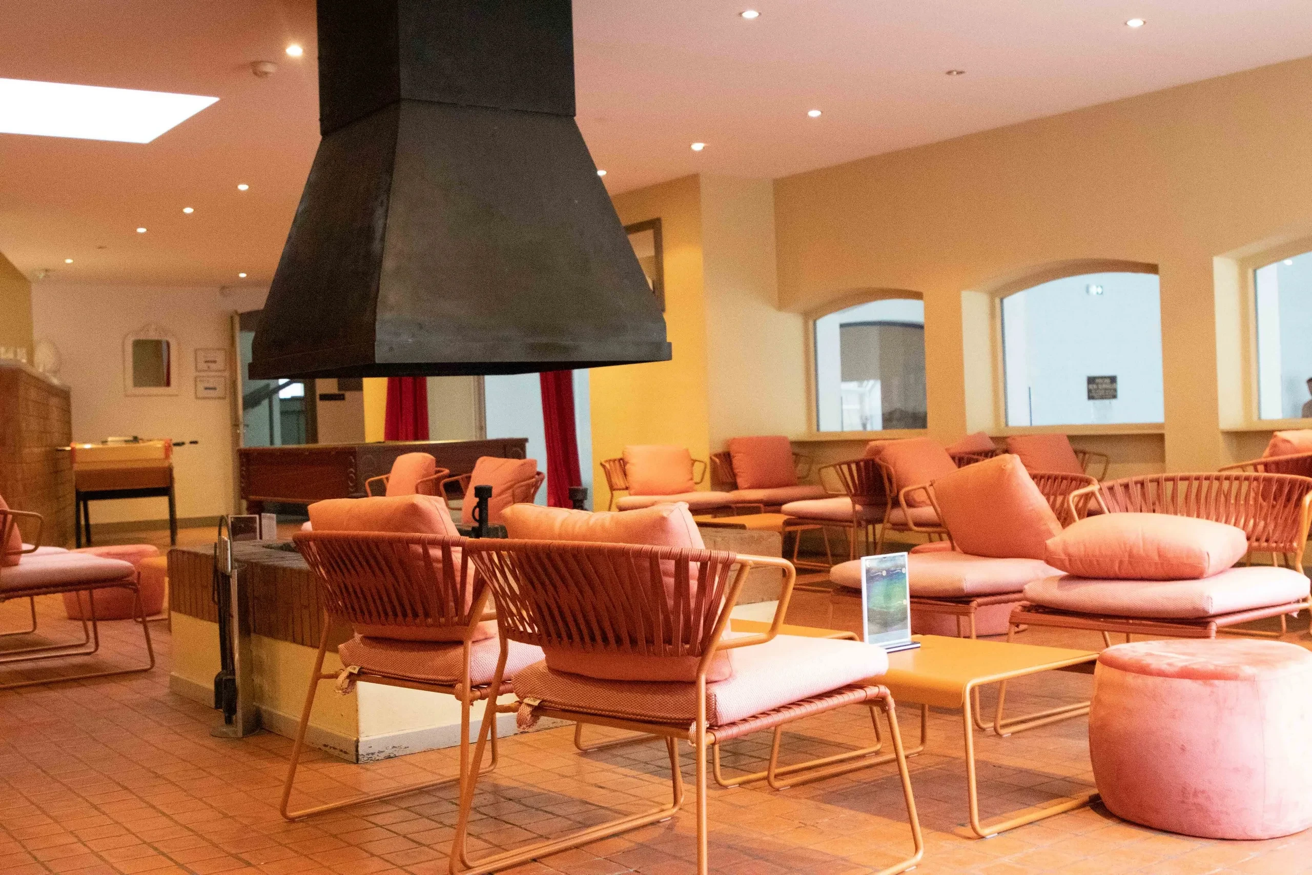 Salon moderne avec fauteuils orange et cheminée noire.